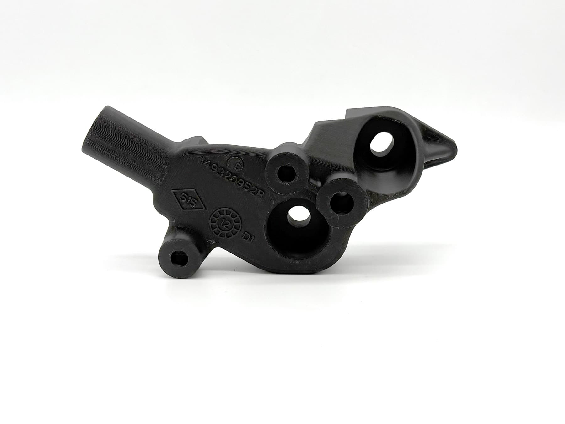 Black 3D printed automotive mounting bracket with molded part-number and material-identification markings, bridging injection-molded OEM parts on the TAKT 3D print farm